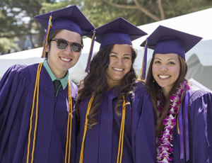 A photo of three graduating students during Commencement at SF State.